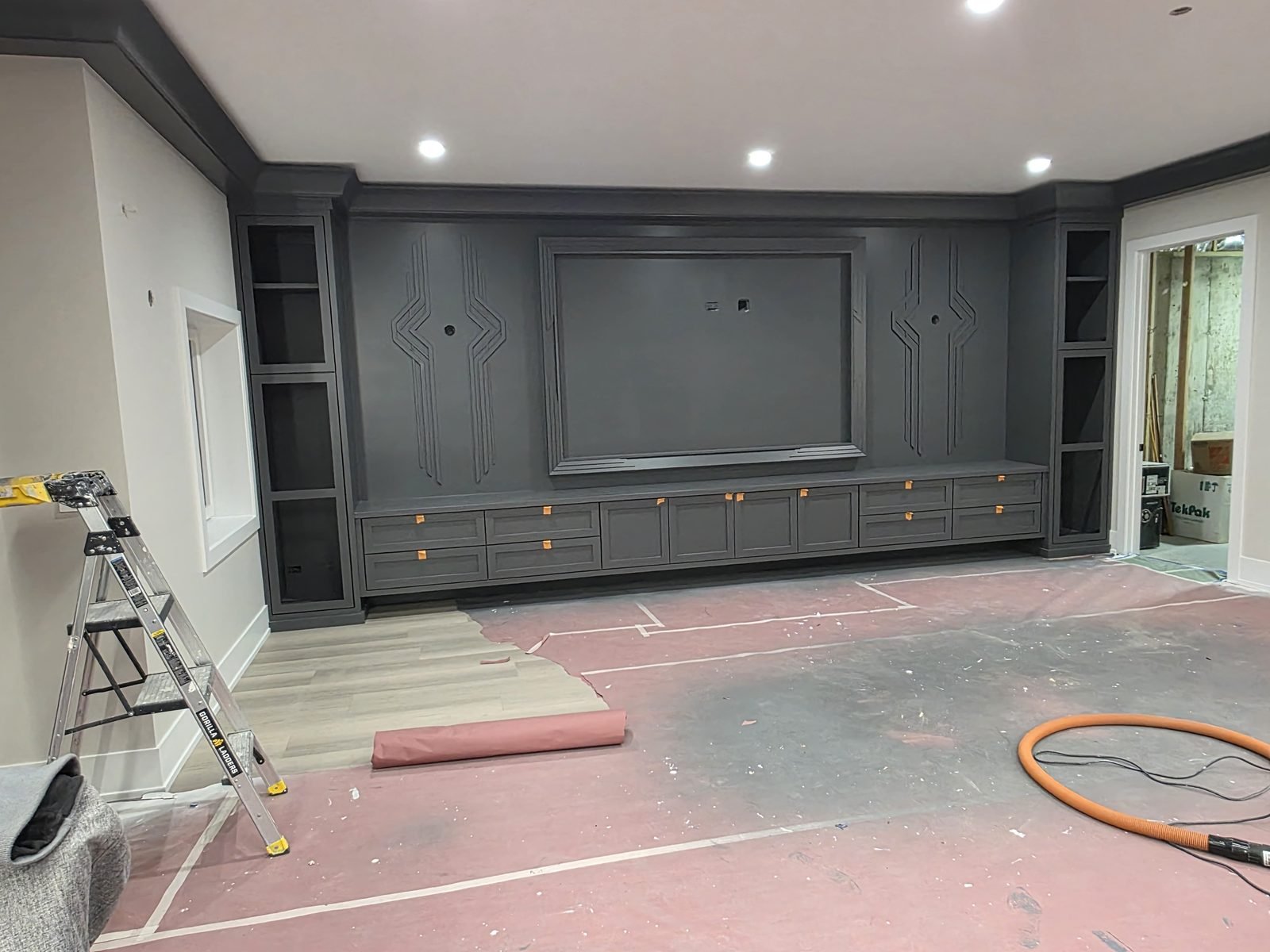 Charcoal media wall with applied art deco moulding and a run of drawers