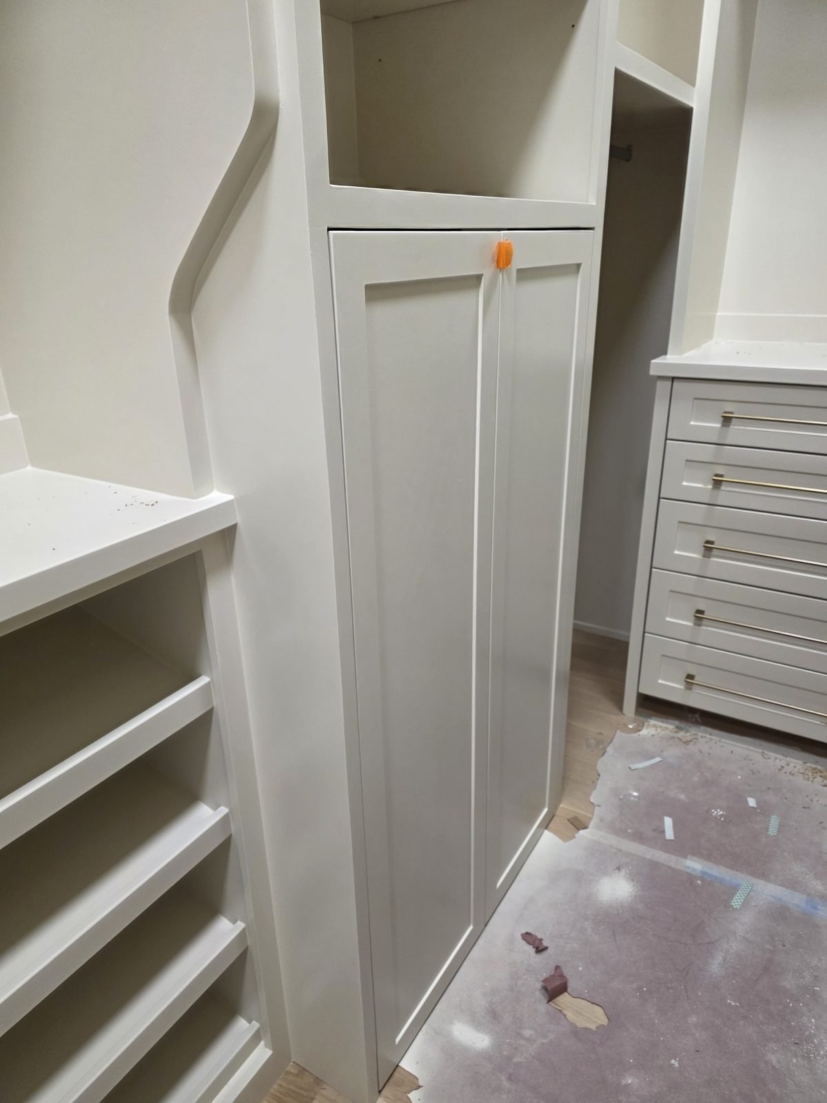 Painted walk-in closet built-ins with drawers and shoe shelving